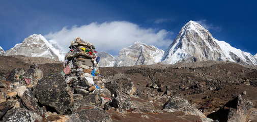 Pumori mount view and stone chorten with lungta prayer flags on the road to Everest Base Camp in...