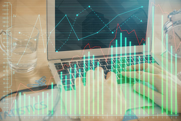 Double exposure of market chart with man working on computer on background. Concept of financial...