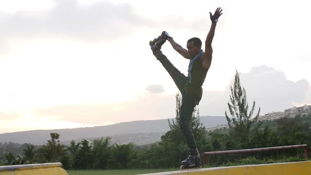 African boy rollerblading on the ramp during the day at summer time 