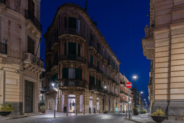 Fototapeta na wymiar Facades of the buildinngs and urban street at night in the Ortygia island, Syracuse in Sicily, Italy