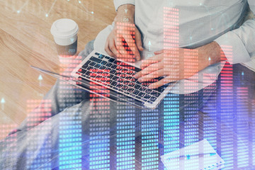 Forex graph with businessman working on computer in office on background. Concept of analysis. Double exposure.