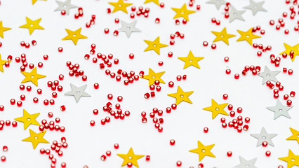 Christmas composition decoration. Pattern made of silver and gold star, golden decorations and red berries on white background.