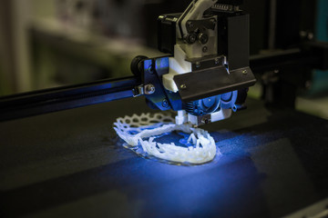 3D printer prints physical 3D model with plastic wire filament at modern technology exhibition. Additive technologies, science and futuristic concept