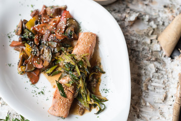 Pan Seared Salmon Steak with Sauteed Vegetables, Greens and Spicy Sauce.
