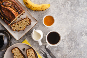 Banana bread. Freshly baked homemade banana pie with honey and butter on a light gray background. View from above