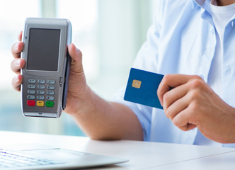 Man processing credit card transaction with POS terminal