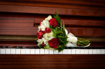 A bouquet of flowers on the piano keys. A bouquet of roses on a musical instrument.