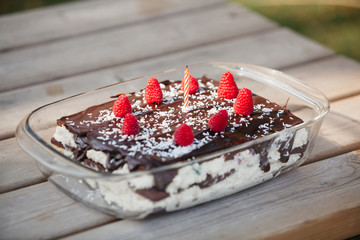 homemade chocolate birthday cake with fresh berries and one candle 