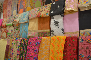 Fancy sarees / unstiched hand woven phulkari chikan embroidery pakistani suits on display in a store Swadeshi khadi handloom exhibition at Dilli Haat, New Delhi, India International Trade Fair (IITF) 