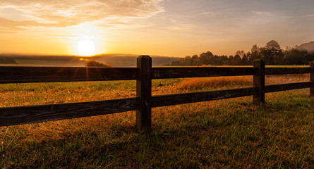 Split rail fence around North Carolina field at sunrise