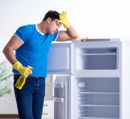 Man cleaning fridge in hygiene concept