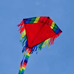 A beautiful, colourful stunt kite, in the blue sky, high up in the wind