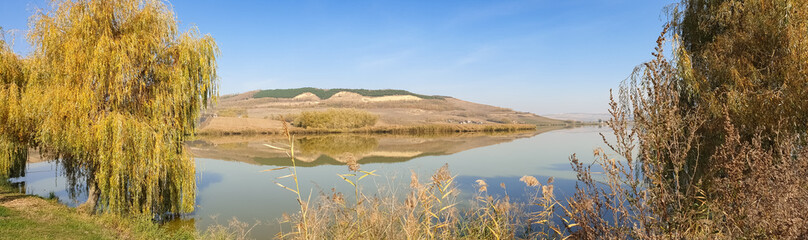 Beautiful panoramic view of calm water of a fishing lake in Transylvania, Romania