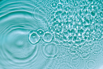 Water abstract background with blue rippled aqua texture, splash circle reflections in swimming pool. Top view