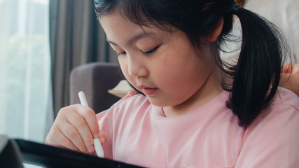 Asian grandparents and granddaughter video call at home. Senior Chinese, grandpa and grandma happy with girl using mobile phone video call talking with dad and mom lying in living room at home.