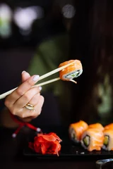 Fotobehang Handen eten sushi met stokjes in café © F8  \ Suport Ukraine