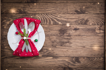 Christmas table place setting with red and white polka dot napkin on the wooden background