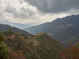 Harvested rice terraces on a hill in a remote village in the Himalayas. Cloudy autumn day. Nepal.