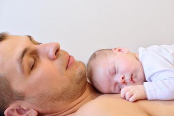 A newborn girl falls asleep on her father