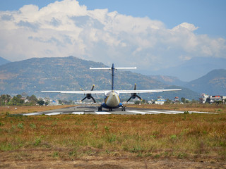  A plane of local, Nepalese airlines on the runway of the airport in Pokhara is preparing for take-off.
