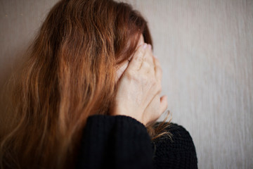 Woman covers her face with fear with fear