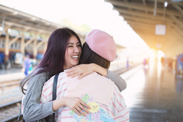 Friend or sister meet after long time concept. Attractive beautiful two woman hugging after long separation from her trip at the train station.