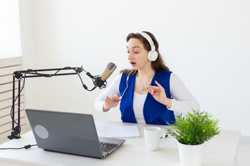 Radio, blogging, podcasting concept - young woman working as a dj on the radio.