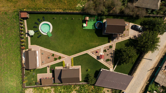 Drone photo of single family house with grey roof and large green grass yard.