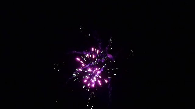 Burst of bright colorful part fireworks on black background to create a set salute on video for holiday new year, birthday, wedding or other celebration.