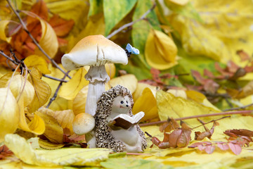 ceramic figurine of a hedgehog in the autumn foliage