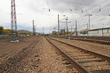 The railway at a small station, a stone embankment and the infrastructure of the railway station.