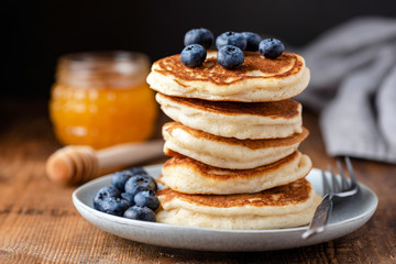 Stack of pancakes with blueberries on a wooden table. Tasty breakfast buttermilk pancakes, american cuisine
