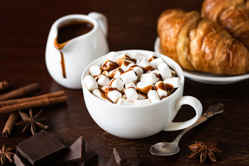 Hot chocolate with marshmallow in white cup on brown wooden table. Hot chocolate with spices winter comfort food