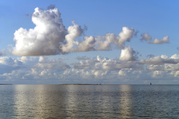 Fototapeta na wymiar Die Nordsee bei Hooksiel im Nationalpark Wattenmeer bei Flut und blauer Himmel und weiße Wolken - Stockfoto