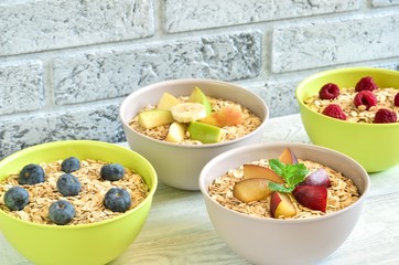 Sweet delicious healthy breakfast. Different porridge with fruit on a wooden kitchen table.