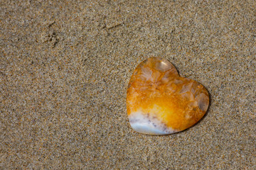 Yellow and white heartt sitting on the beach