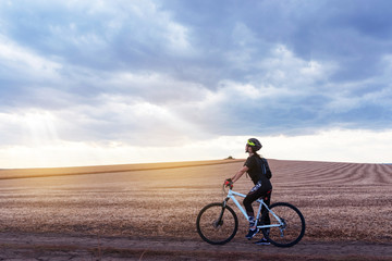Obraz premium sport girl on a mountain bike in the evening field