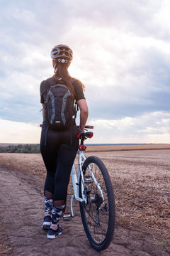 Sport Girl Near Mountain Bike Watching The Horizon In The Field