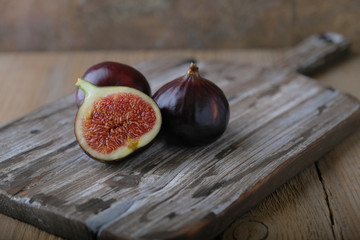 Fresh ripe figs and cut in half on a wooden table.