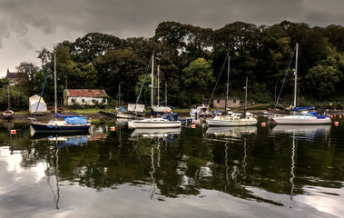Fototapeta na wymiar Abandoned boat house with yachts moored alongside the river estury