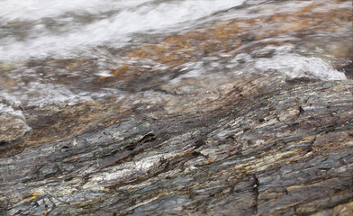 Water flowing over washed out slate stone structures