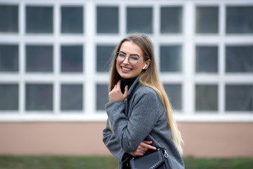Fototapeta premium Young beautiful blonde with glasses on the city streets.