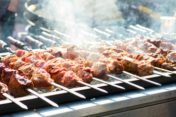 Mixed grilled meat platter. Assorted delicious grilled meat. Meat on skewers is roasted on fire. Meat with smoke on a barbecue grill over charcoal