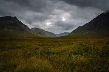 Mountain landscape in the Glen Coe with dark clouds hanging over the peaks, Highland, Scotland