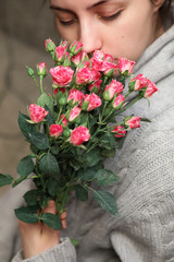 Fototapeta na wymiar bouquet of bush of roses in female hands on a background