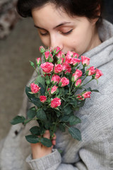 bouquet of bush of roses in female hands on a background