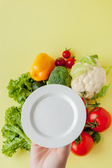 Plate for tasty diet on background Fresh vegetables . Top view. Food cooking background