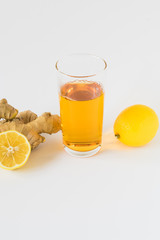 Glass of tea with lemon and ginger on a white background. The concept of tea from colds and to improve immunity. Detox drink components