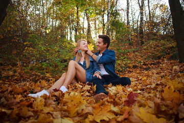 Loving happy young couple in forest park in autumn on nature at sunset background