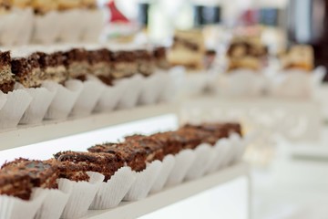 Assortment of pieces of cake on messy table, copy space. Several slices of delicious desserts, restaurant menu concept, top view